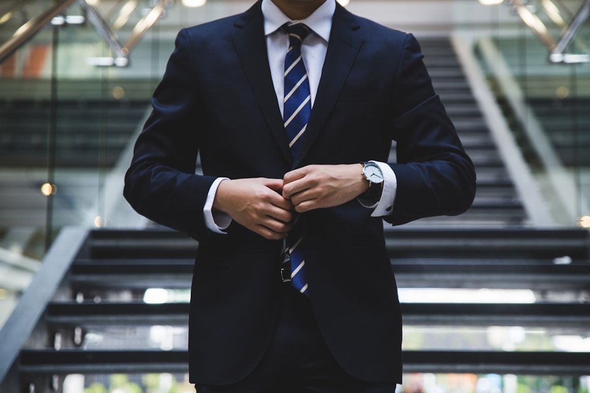 A senior professional in a navy suit in a bright office setting